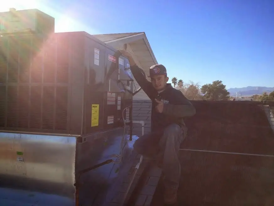 HVAC technician performing Heat Pump Repair on a rooftop unit in Caldwell
